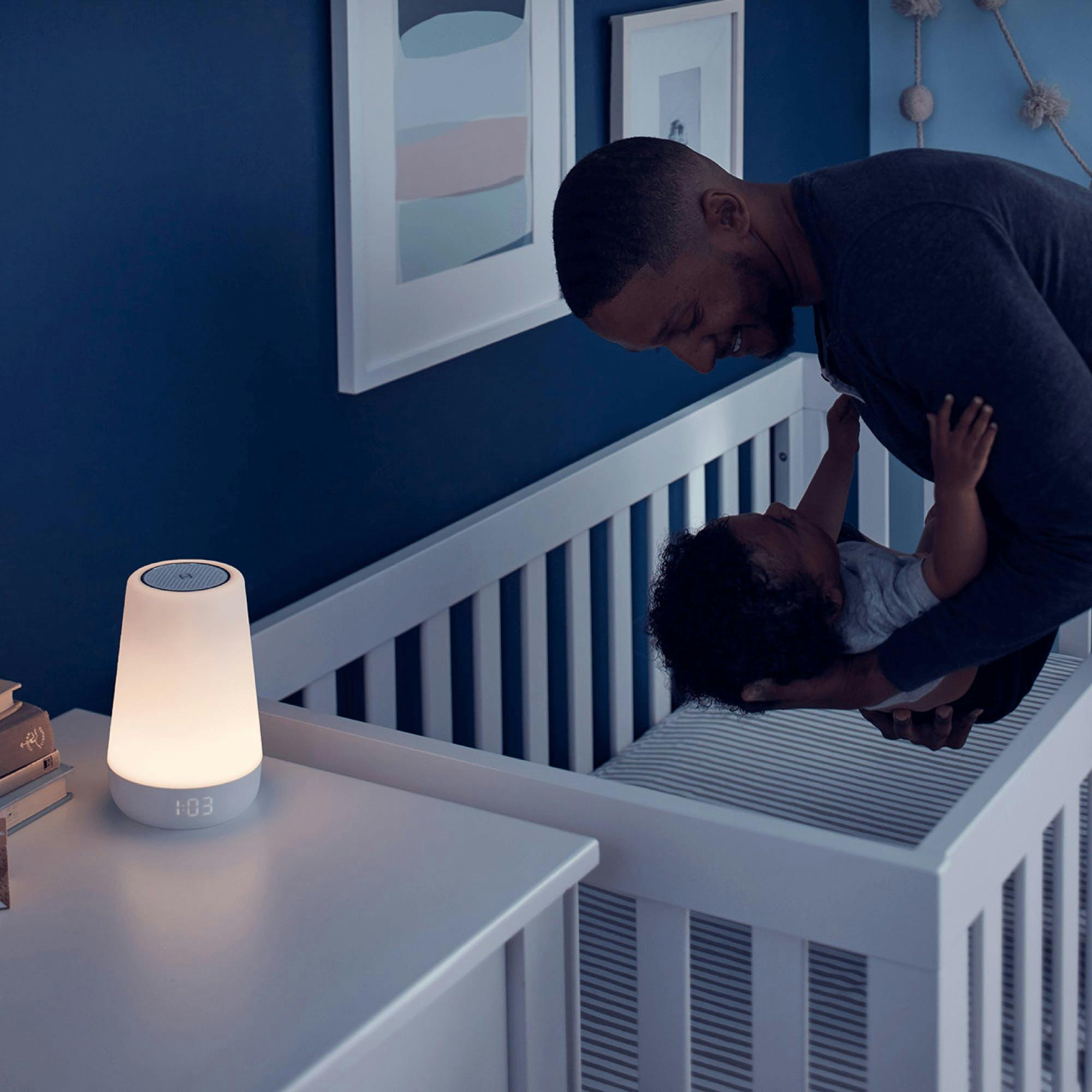 A father puts a baby into crib at night